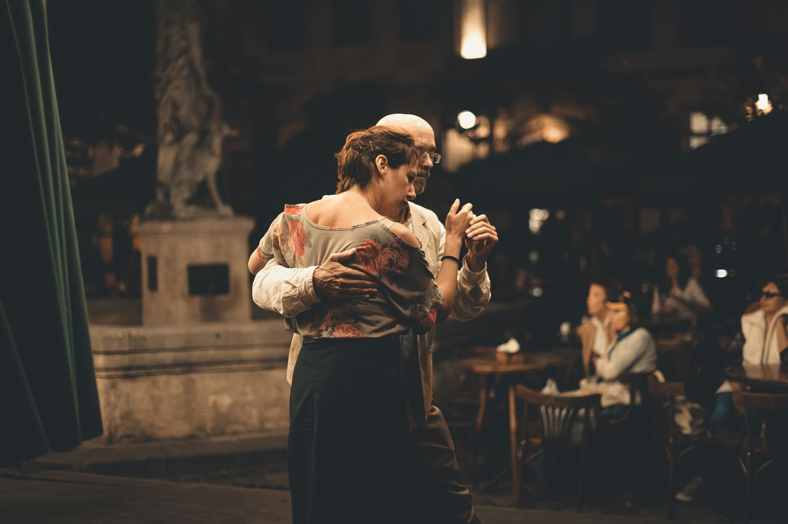 couple-dance-of-disconnection-heartsprout-therapy A couple dances closely in the soft evening light, holding each other with a mix of tenderness and melancholy.
