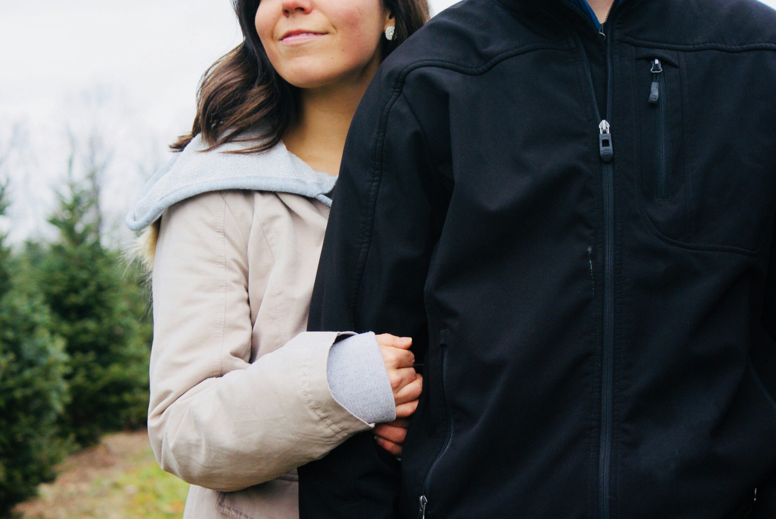 A woman holding her partner’s arm outdoors, symbolizing safety, connection, and trust — HeartSprout Therapy.